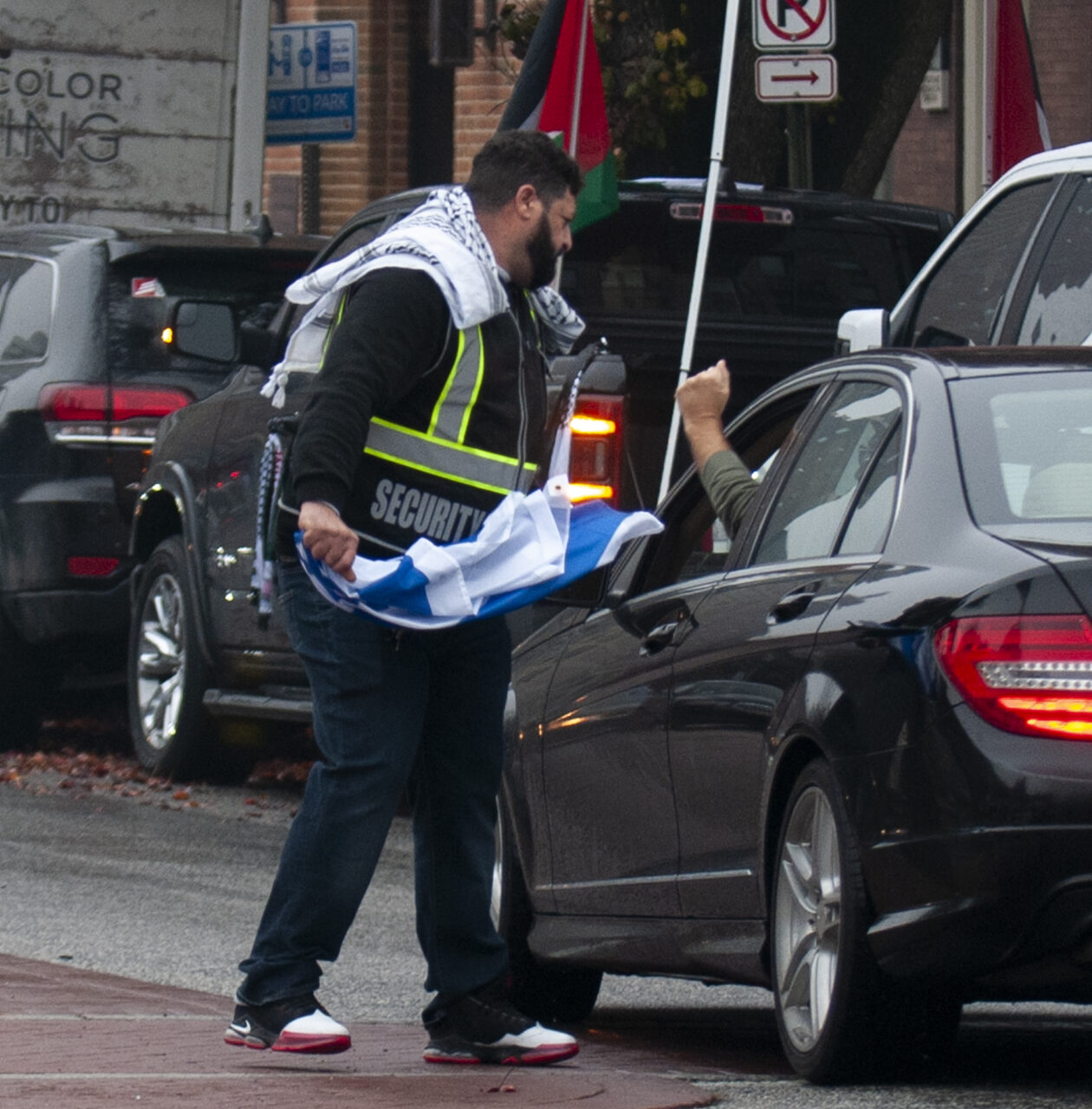 A man snatches an Israel flag from a man who drove past past hundreds gathered at the state capitol building in Harrisburg on Dec. 10, 2023 calling for a permanent cease fire in the war between Israel and Palestine. Jeremy Long - WITF