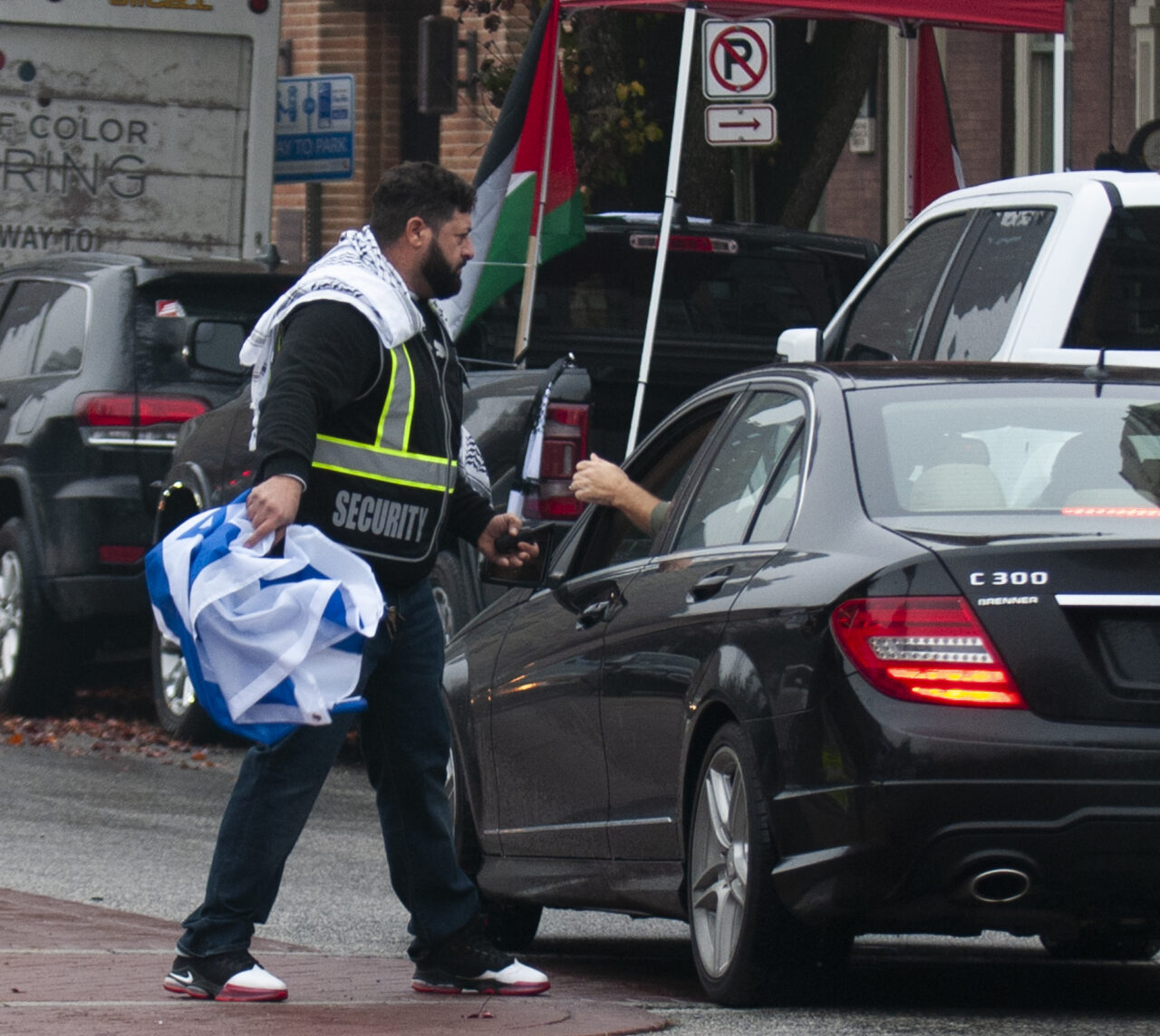 A man snatches an Israel flag from a man who drove past past hundreds gathered at the state capitol building in Harrisburg on Dec. 10, 2023 calling for a permanent cease fire in the war between Israel and Palestine. Jeremy Long - WITF