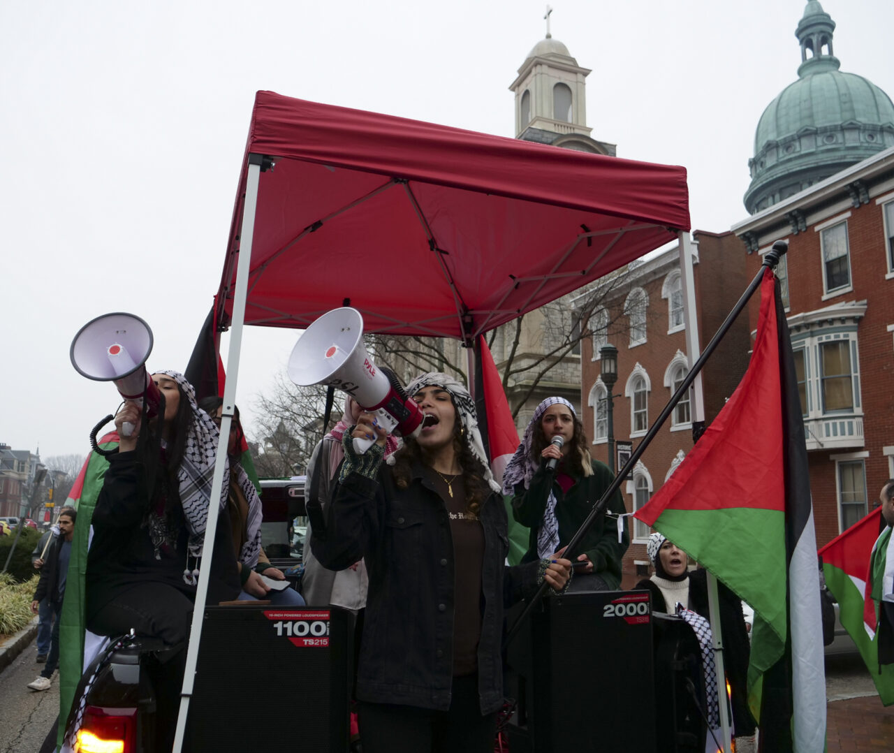 People shout chants from the back of a pickup truck as hundreds march down State Street after they gathered at the state capitol building and marched to the governor's residence in Harrisburg on Dec. 10, 2023 calling for a permanent cease fire in the war between Israel and Palestine. Jeremy Long - WITF