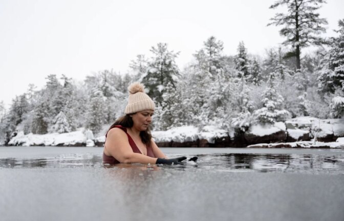 Vermont resident Tanya Talamante pauses in the icy water on Jan. 20, 2023, at Oakledge Park and Beach in Burlington, VT. (Raquel C. Zaldívar/New England News Collaborative)