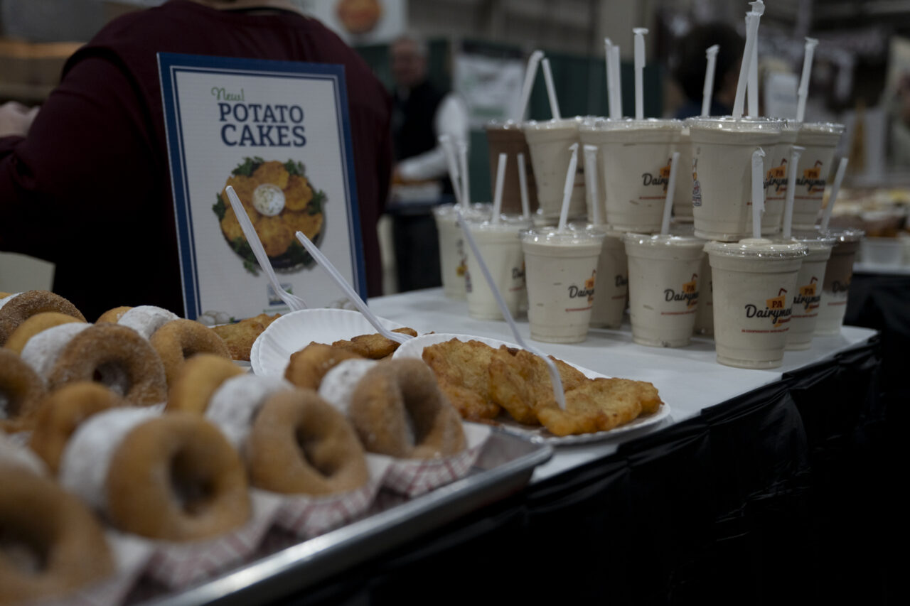 Potato doughnuts and potato pancakes sit alongside a stack of milkshakes at the 2024 Farm Show. Ben Wasserstein- WITF