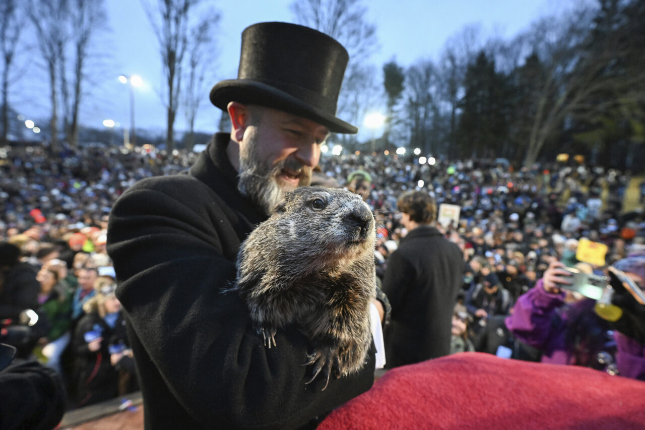 Groundhog Club handler A.J. Dereume holds Punxsutawney Phil, the weather prognosticating groundhog, during the 138th celebration of Groundhog Day on Gobbler's Knob in Punxsutawney, Pa., Friday, Feb. 2, 2024. Phil's handlers said that the groundhog has forecast an early spring. (AP Photo/Barry Reeger)