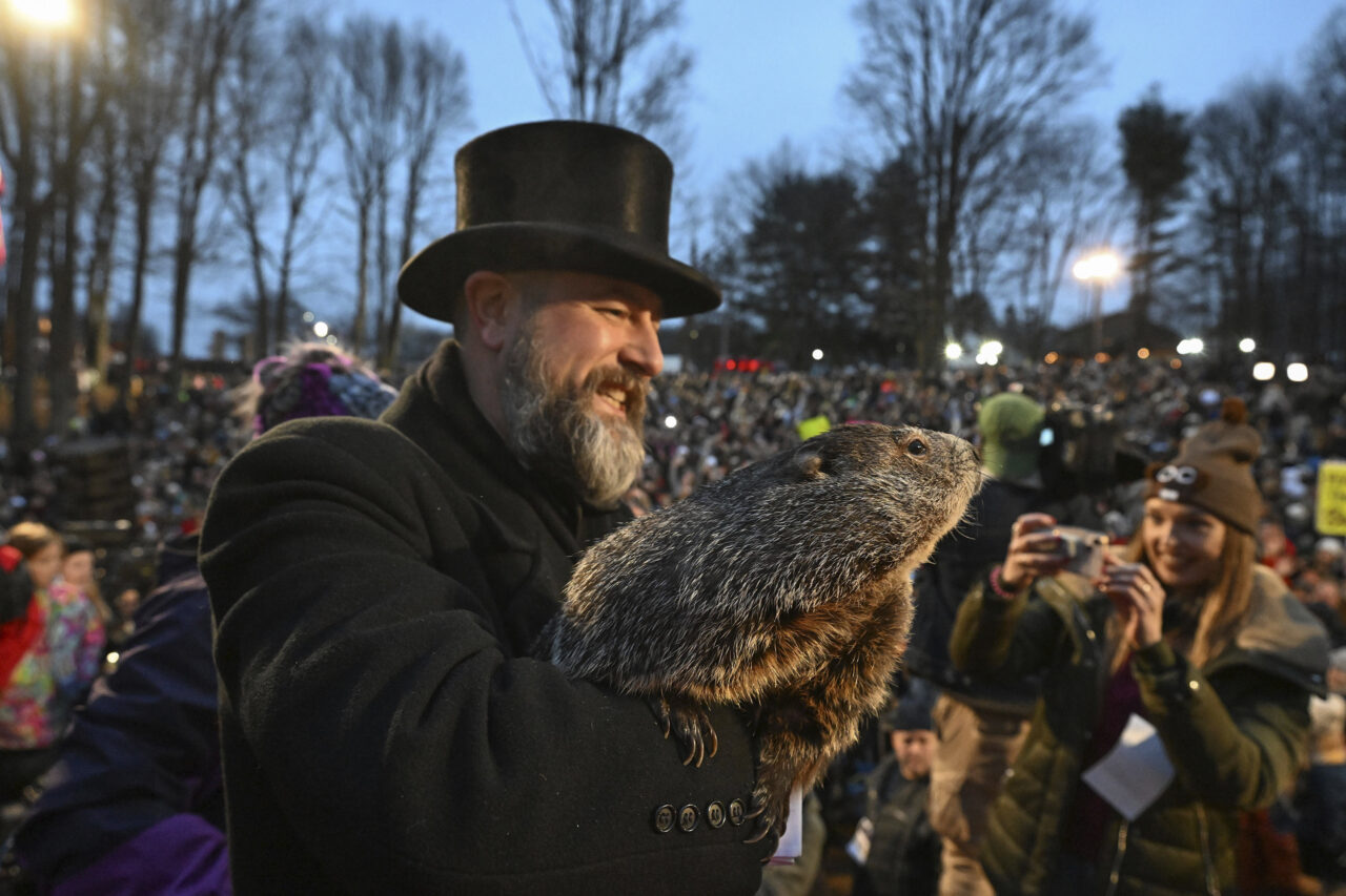 Groundhog Club handler A.J. Dereume holds Punxsutawney Phil, the weather prognosticating groundhog, during the 138th celebration of Groundhog Day on Gobbler's Knob in Punxsutawney, Pa., Friday, Feb. 2, 2024. Phil's handlers said that the groundhog has forecast an early spring. (AP Photo/Barry Reeger)