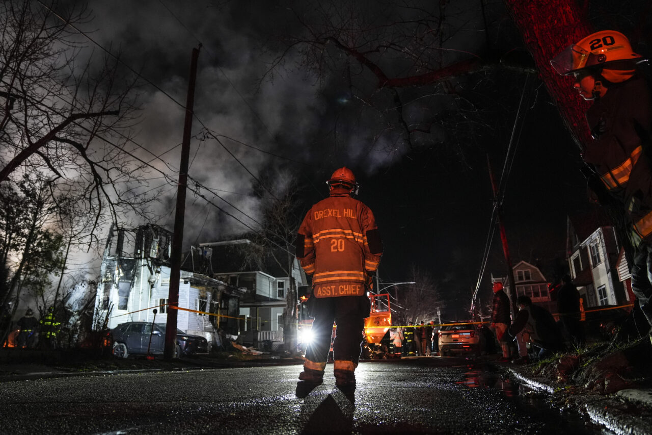 Firefighters work at the scene where two police officers were injured while responding to reported standoff in East Lansdowne, Pa., on Wednesday, Feb. 7, 2024. (AP Photo/Matt Rourke)