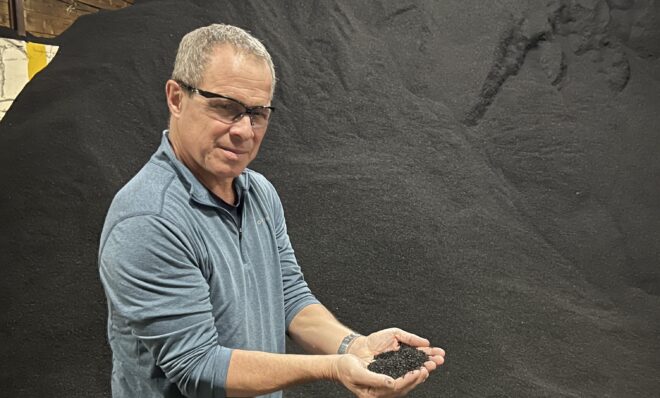 Ecore's Brett Anderson shows some of the rubber particles the company uses to make flooring. 