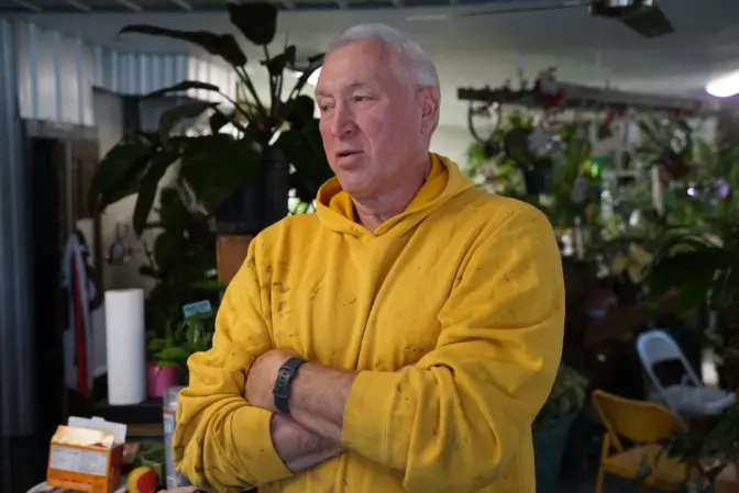 Don Elzer stands at the checkout counter in a retail greenhouse where he said business has been down about 20% since the derailment.