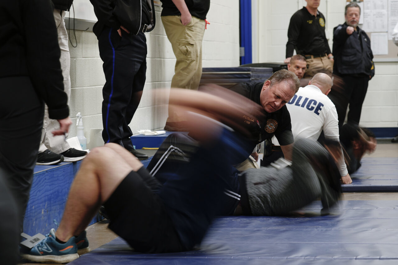 Philadelphia Police Academy staff count sit ups during applicants' physical fitness entry exam in Philadelphia, Saturday, Feb. 24, 2024. The city has moved to lower requirements for the entry physical exam at its police academy as part of a broader effort nationally to reevaluate policies that keep law enforcement applicants out of the job pool amid a hiring crisis. (AP Photo/Matt Rourke)