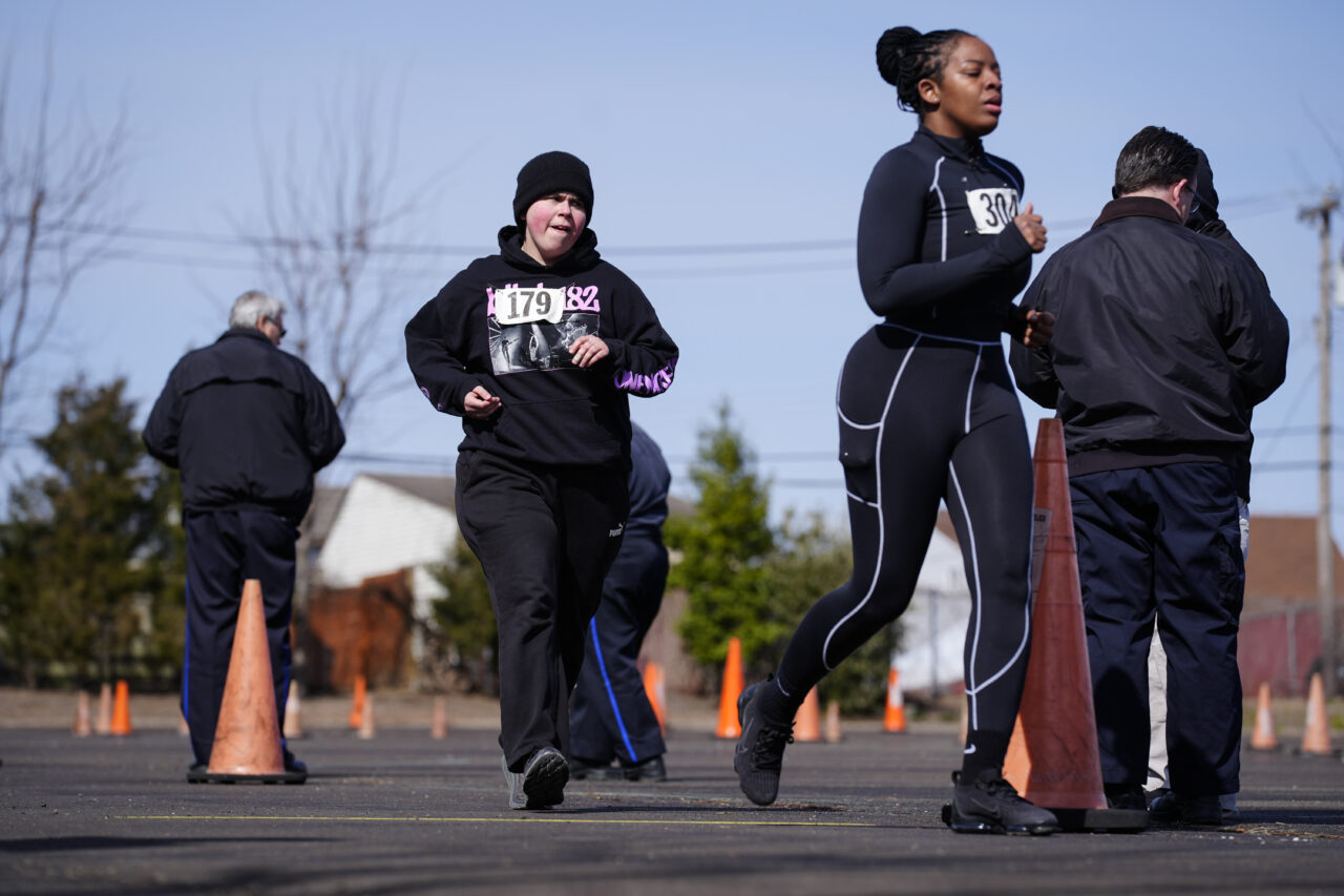 Philadelphia Police Academy applicant Megan Bortner, center, takes part in the 1.5 mile run as part the physical fitness entry exam in Philadelphia, Saturday, Feb. 24, 2024. The city has moved to lower requirements for the entry physical exam at its police academy as part of a broader effort nationally to reevaluate policies that keep law enforcement applicants out of the job pool amid a hiring crisis. (AP Photo/Matt Rourke)