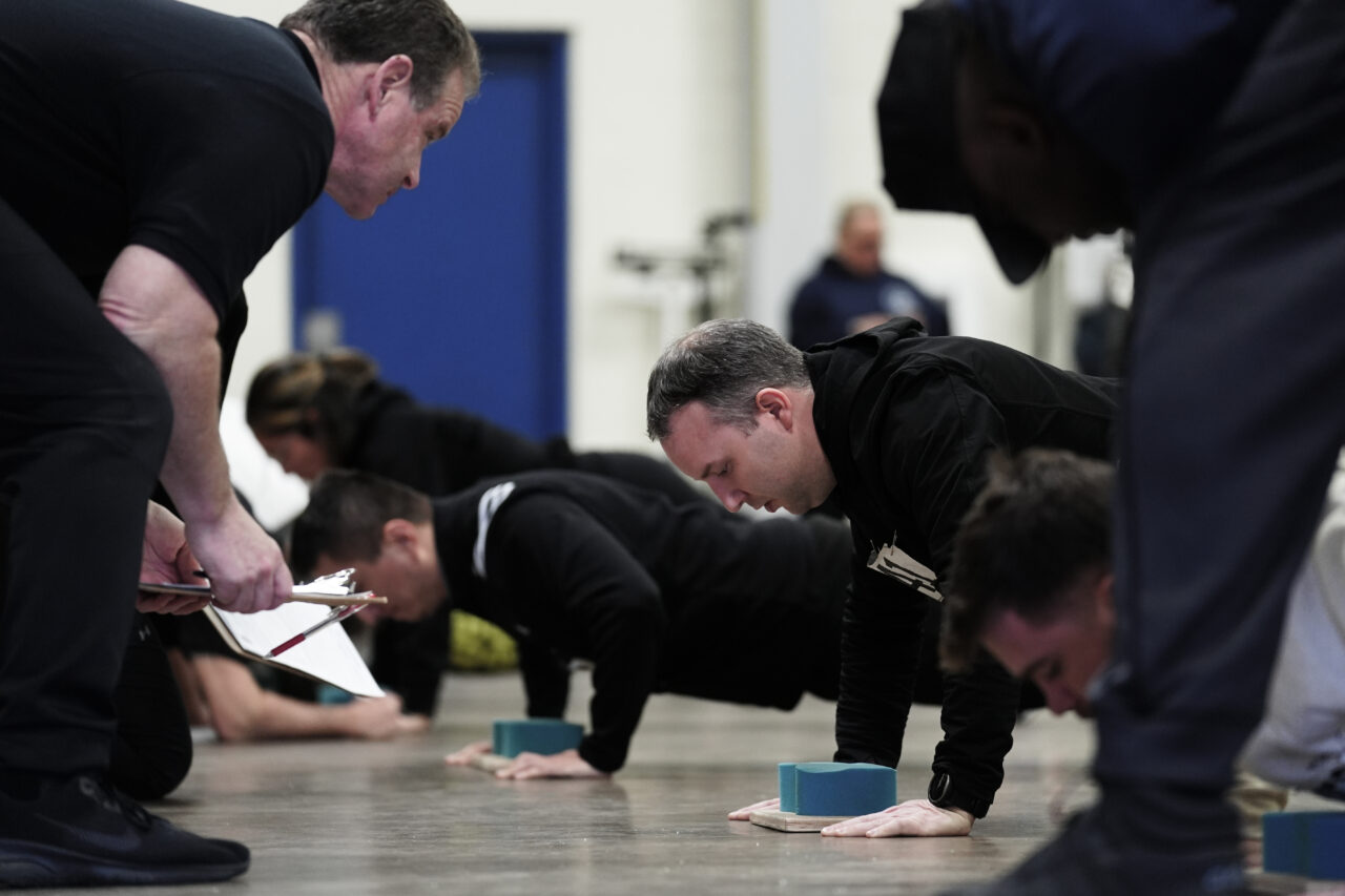 Philadelphia Police Academy staff count push ups during applicants' physical fitness entry exam in Philadelphia, Saturday, Feb. 24, 2024. The city has moved to lower requirements for the entry physical exam at its police academy as part of a broader effort nationally to reevaluate policies that keep law enforcement applicants out of the job pool amid a hiring crisis. (AP Photo/Matt Rourke)