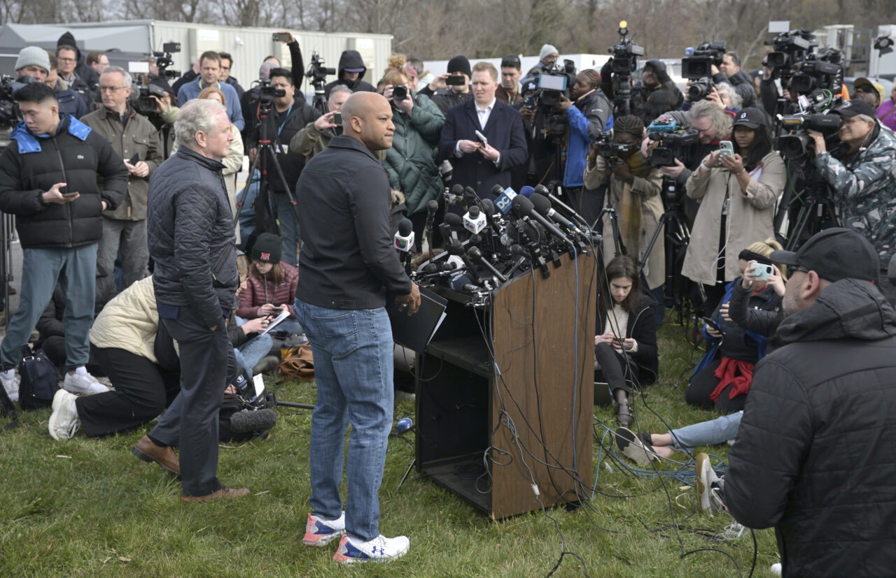 Maryland Gov. Wes Moore, center, holds a news conference near the scene where a container ship collided with a support on the Francis Scott Key Bridge, Tuesday, March 26, 2024 in Baltimore. The major bridge in Baltimore snapped and collapsed after a container ship rammed into it early Tuesday, and several vehicles fell into the river below. Rescuers were searching for multiple people in the water. (AP Photo/Steve Ruark)