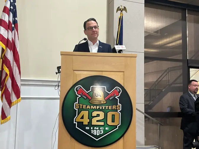 Gov. Josh Shapiro pauses after environmentalist Maya van Rossum disrupts his speech Monday at the Steamfitters Local 420 union hall in Northeast Philadelphia. (Susan Phillips/WHYY)
