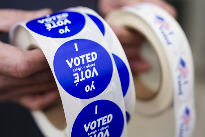 A poll worker holds voting stickers for community members Nov. 7, 2023, at Central Elementary School in Allentown, Lehigh County, Pennsylvania. (Matt Smith For Spotlight PA)