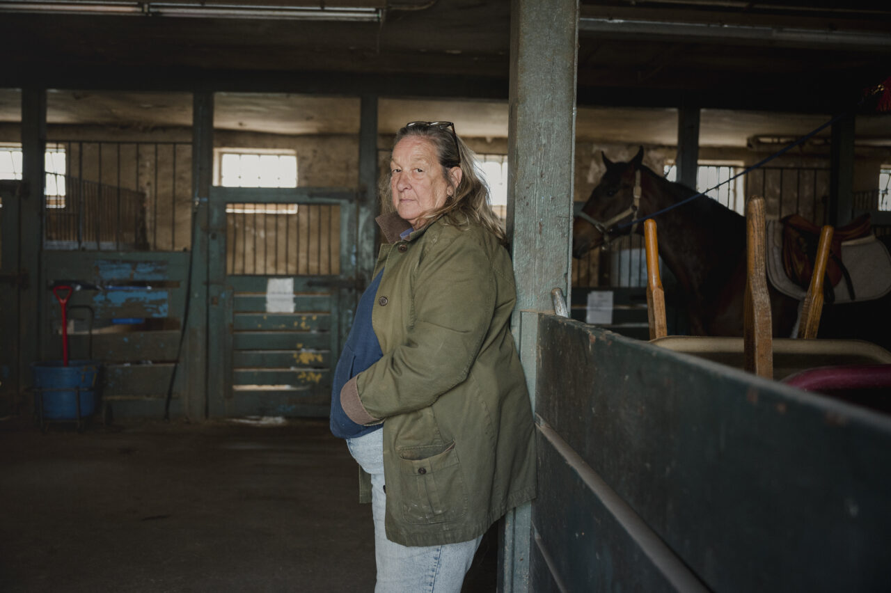 Lezlie Hiner, owner and founder of Work to Ride, stands for a portrait at the Northwestern Stables in Philadelphia, PA, on Saturday March 30 2024. Work to Ride is an after school program for disadvantaged youth in Philadelphia which aims to teach teenagers to care for animals, be outdoors and learn the sport of polo. Hannah Yoon for NPR