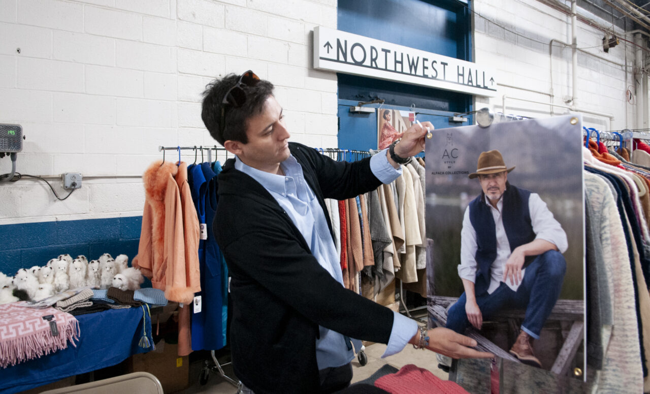 Sebastian Romero-Ortega, a salesman with Alpaca Collections sets up his booth on April 5, 2024 at the Eastern Alpaca Jamboree held at the Pennsylvania Farm Show Complex. (Jeremy Long - WITF)