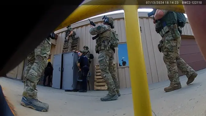 A number of law enforcement officers converge on the building where the gunman is shooting from the roof.