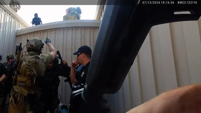 Law enforcement officers attempt to reach the rooftop where the gunman was shooting from.