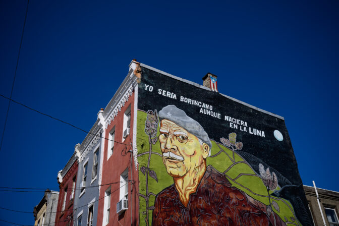 A mural featuring the likeness of Puerto Rican poet, journalist and activist Juan Antonio Corretjer is painted on the side of a building in the Fairhill neighborhood of Philadelphia on Friday, September 20, 2024. The text, a famous line from one of his poems, reads, "I would be [Puerto Rican] even if I were born on the moon." CREDIT: Kriston Jae Bethel for NPR