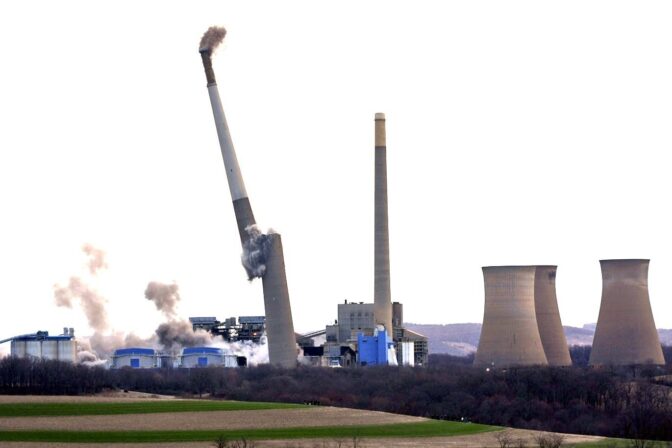 The smokestacks and cooling towers of the former coal-fired Homer City Generating Station crumble in a planned demolition to make way for a new natural gas-fired power plant in Homer City, Pa., Saturday, March 22, 2025. (AP Photo/Gene J. Puskar)
