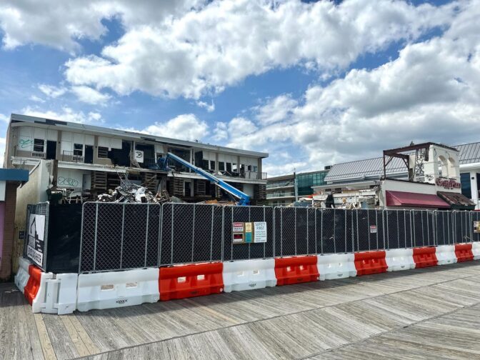 What was once a hotel, motel, and a row of small retail shops is now a dusty, fenced-off construction zone, marked with caution signs and frustration. Locals and visitors alike have voiced concerns over the noise and the site’s rough aesthetics. (Johnny Perez-Gonzalez/WHYY)