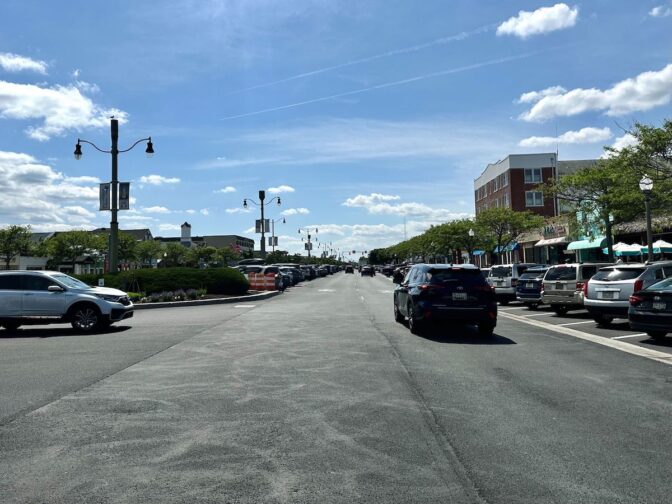 Meanwhile, Rehoboth Avenue is buzzing with activity—parking is scarce, and drivers circle the area in search of spots as foot traffic filters into local shops and eateries. (Johnny Perez-Gonzalez/WHYY)