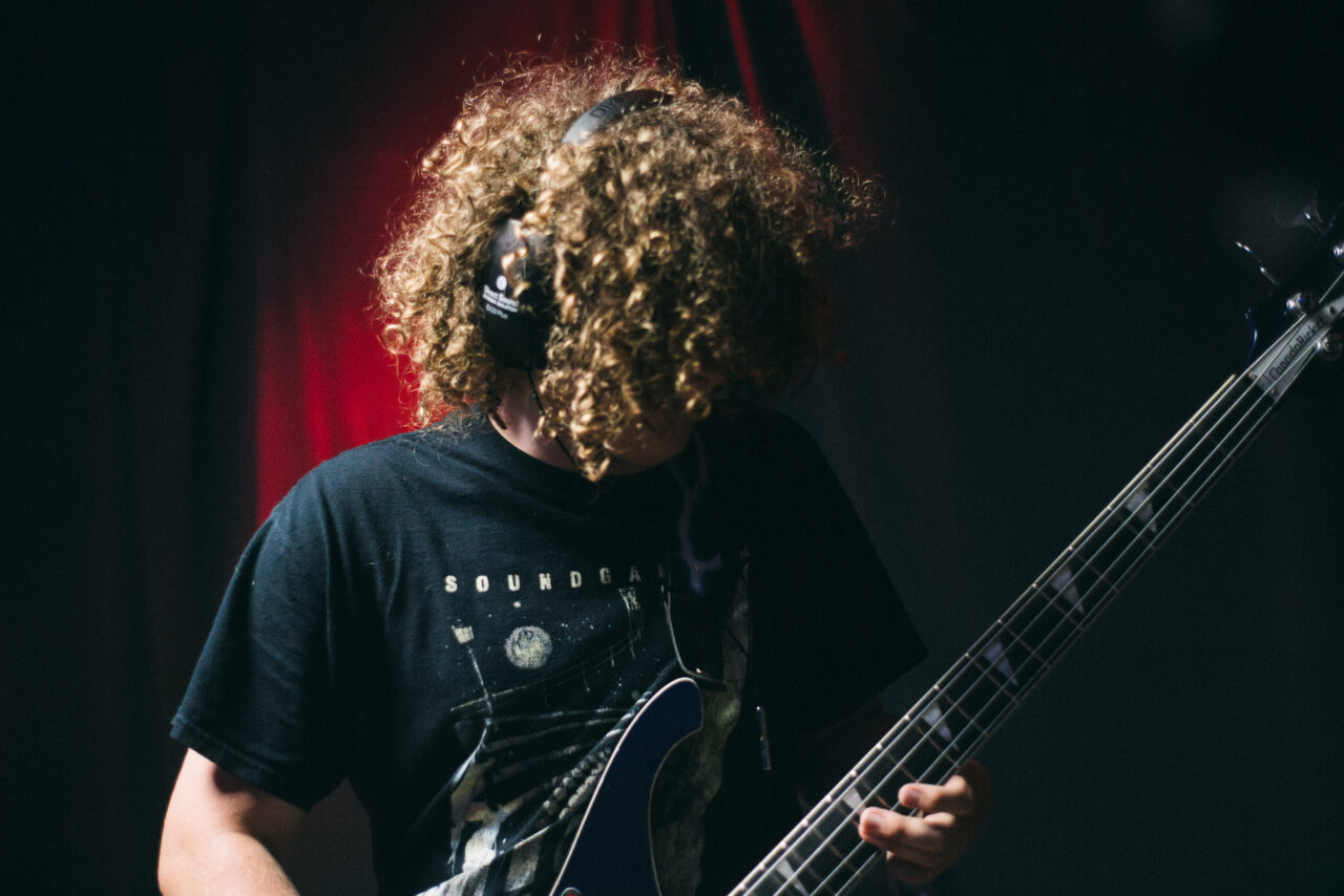A person playing a bass guitar.