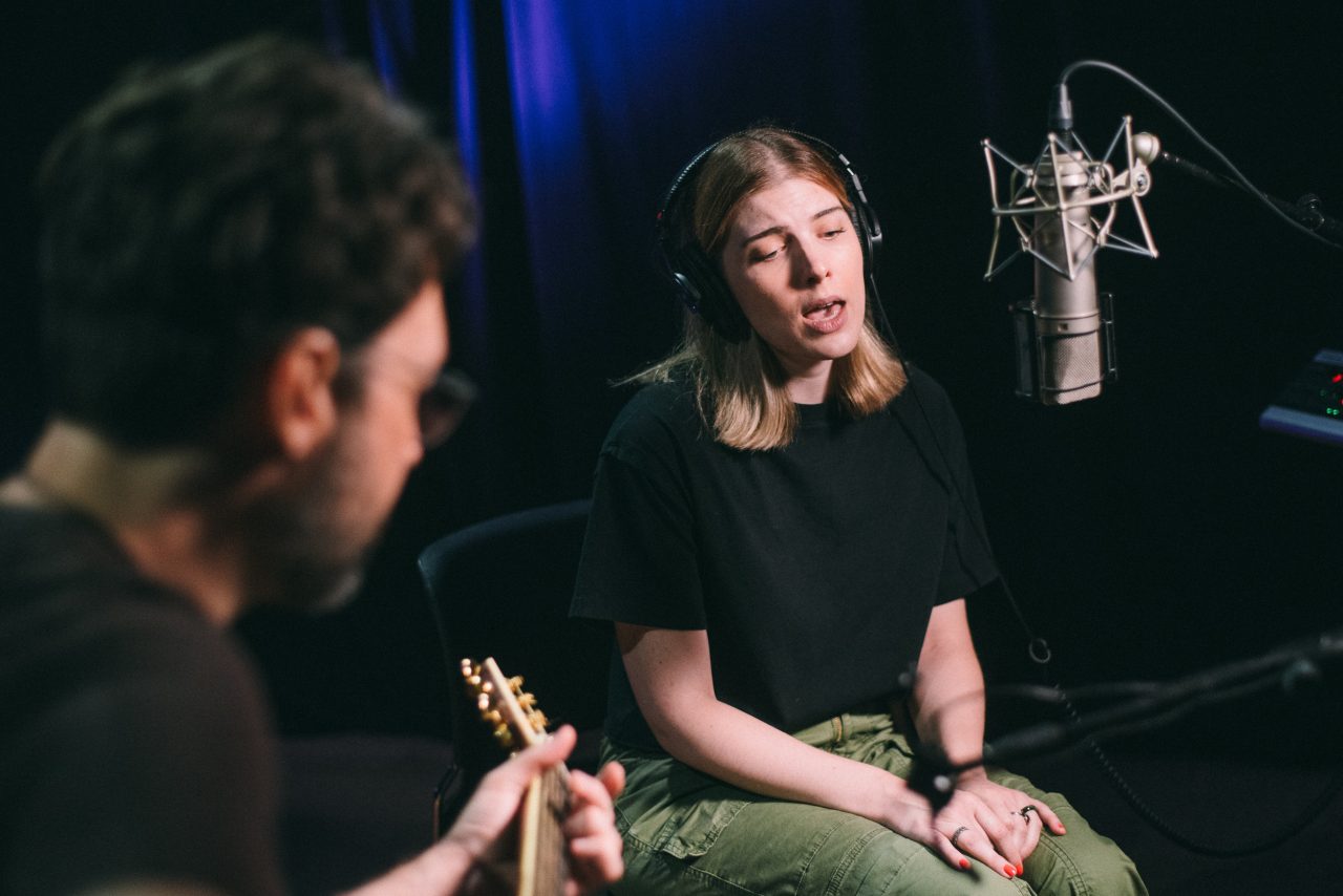An image of Olivia Elizabeth Basar and guitarist Tyler Adkins performing.