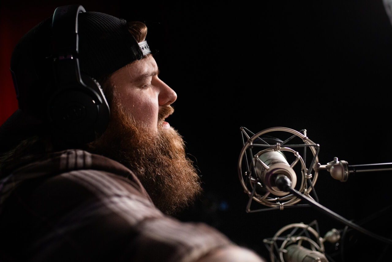 Jake Mach singing and playing guitar.