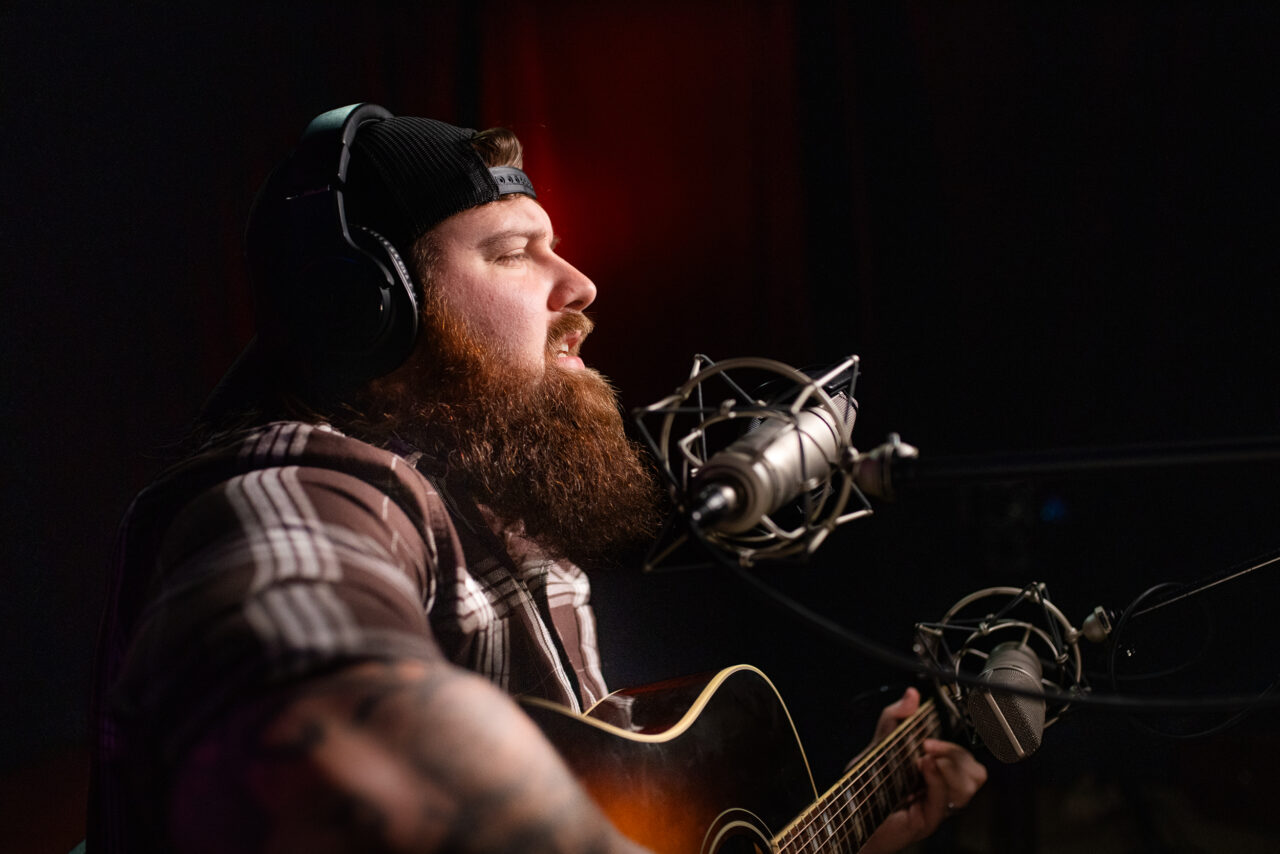Jake Mach singing and playing guitar.