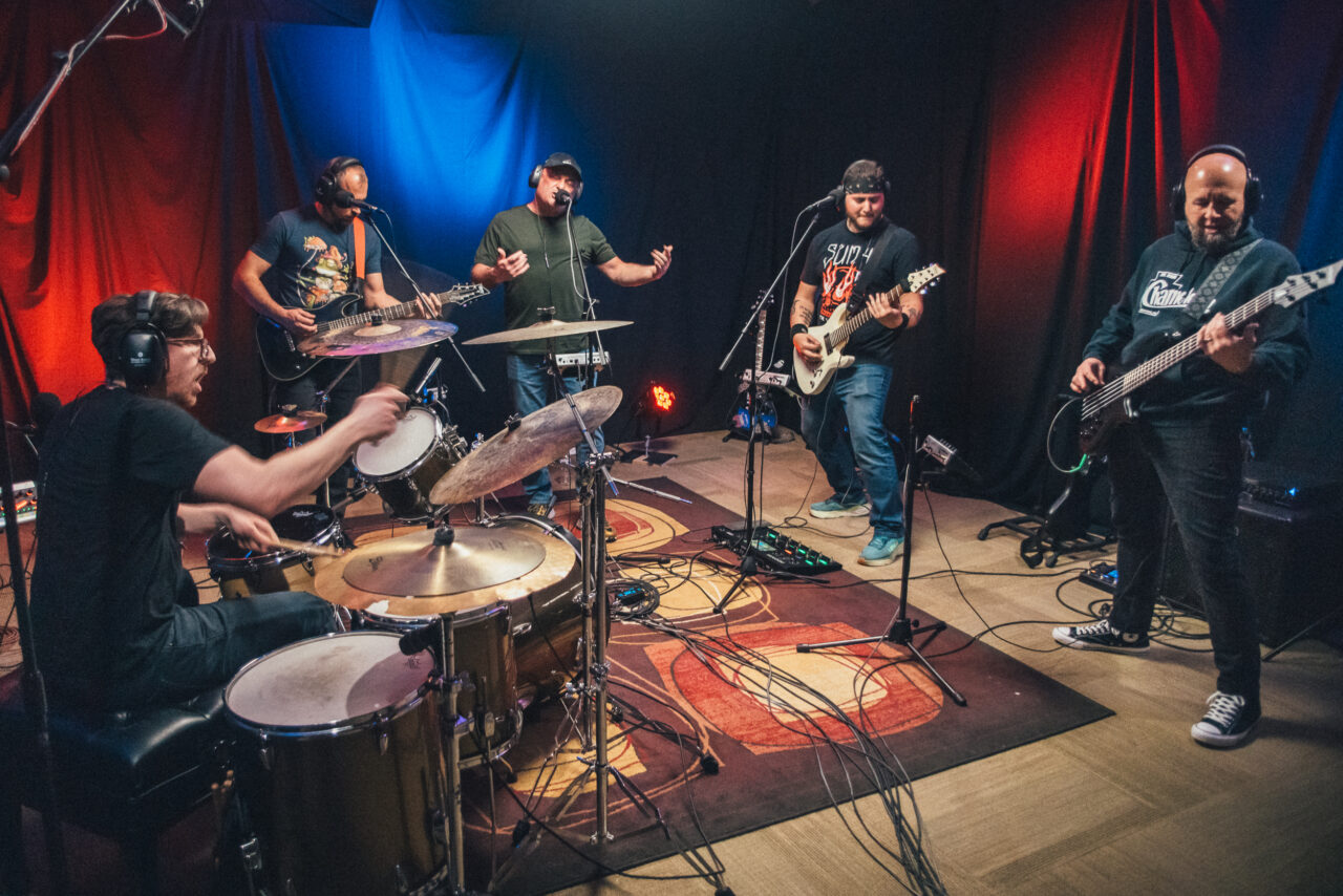 A band performing in a small studio.