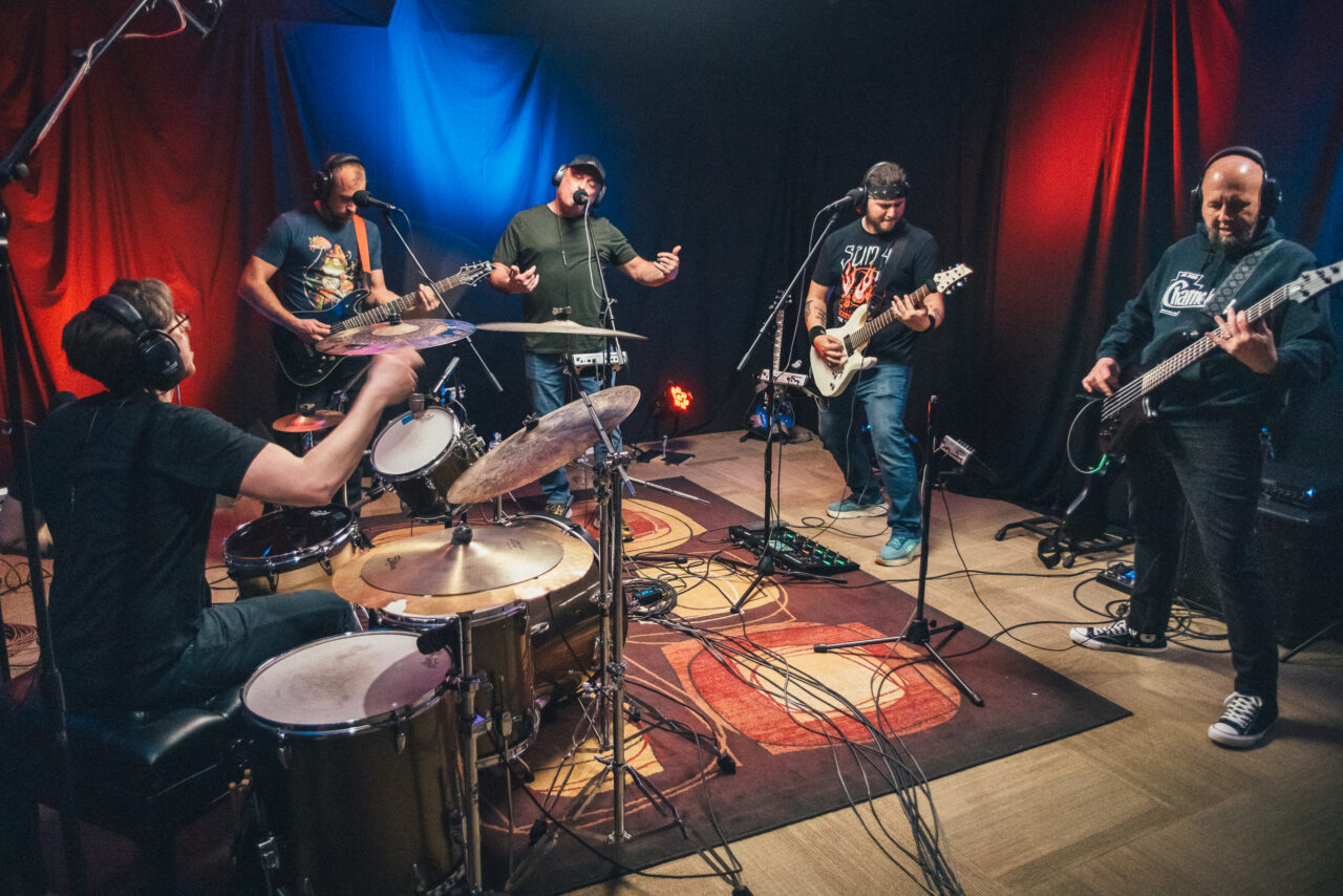 A band performing in a small studio.