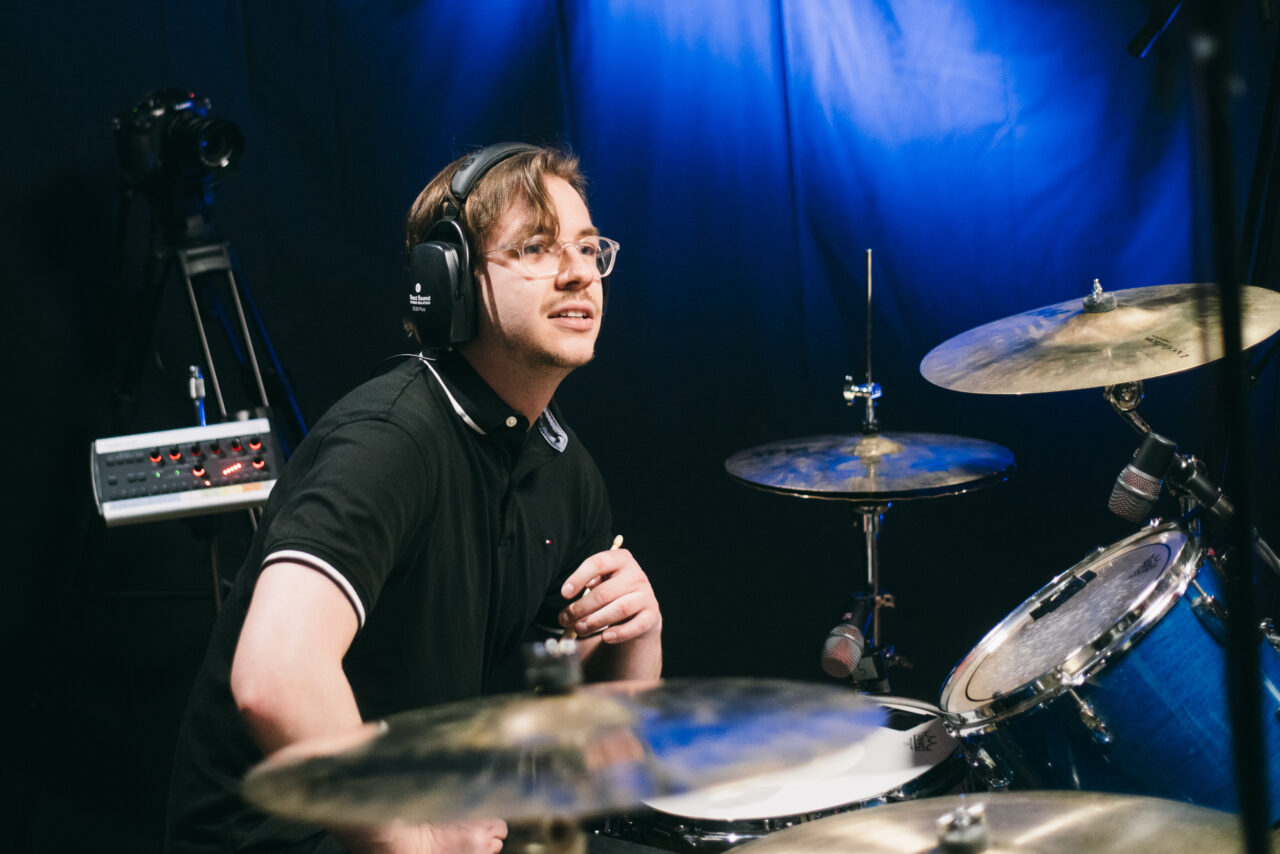 A person sitting at a drum set.